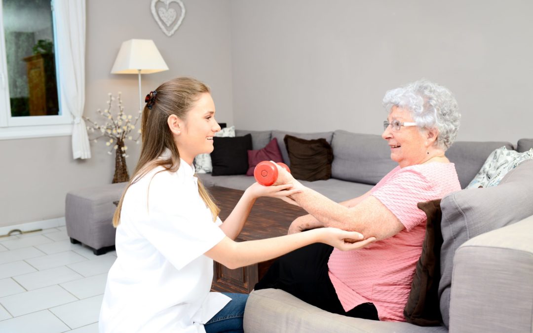 young physiotherapist nurse helping elderly women physical rehabilitation at home